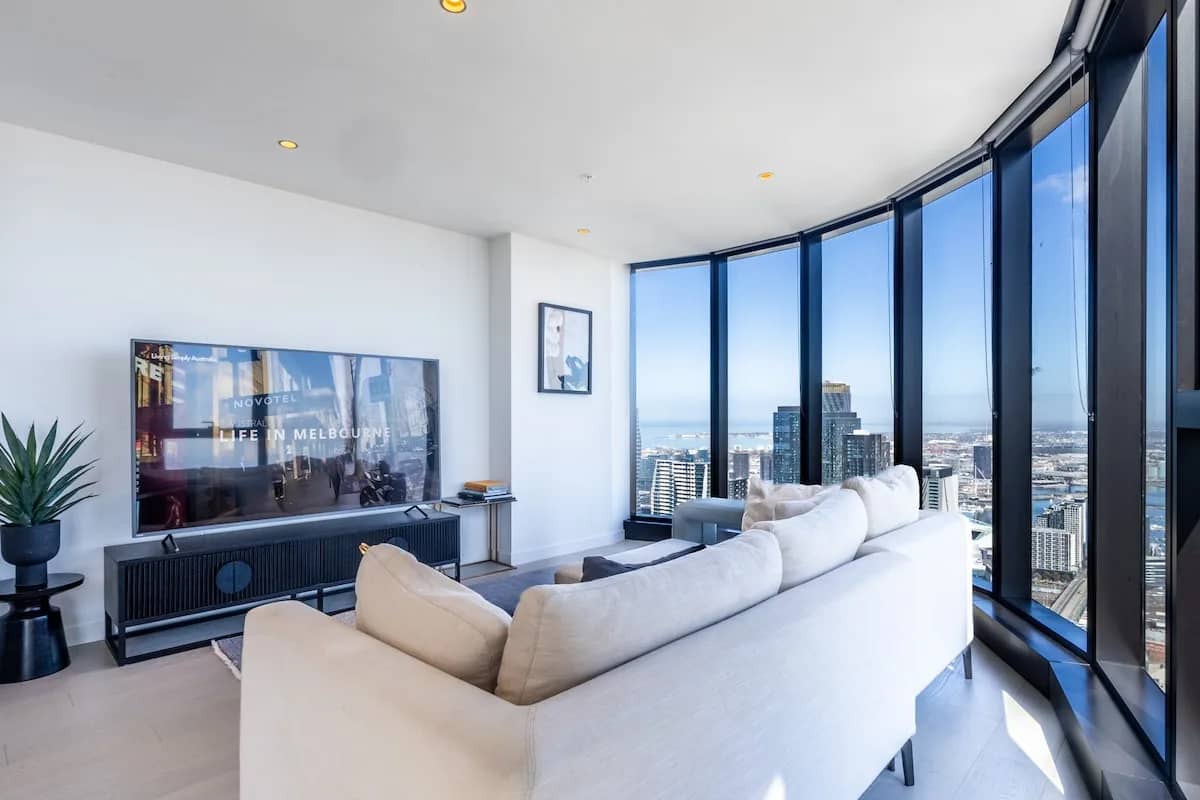 Modern living room with floor-to-ceiling windows overlooking city skyline
